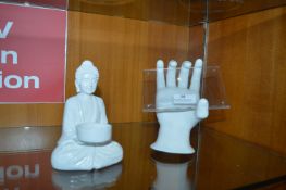 White Buddha Figurine and a Hand
