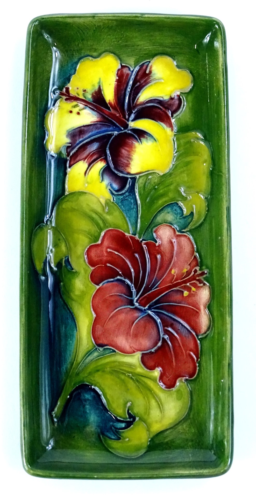 A Moorcroft Fuschia pattern rectangular tray, decorated with flowers on a green ground, impressed