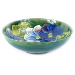 A Moorcroft Clematis pattern bowl, decorated with flowers, on a green ground, impressed mark and