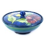 A Walter Moorcroft Hibiscus pattern bowl and cover, decorated with flowers, on a cobalt blue and