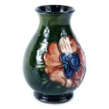 A Walter Moorcroft small Anemone pattern baluster vase, on a mottled turquoise ground, paper label