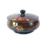 A Moorcroft Flambe Orchid pattern box and cover, on a mottled blue and brown ground, impressed
