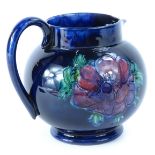 A Walter Moorcroft Anenome pattern pottery jug, on a cobalt blue ground, impressed mark to