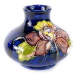 A Moorcroft Columbine pattern squat vase, decorated with flowers on a cobalt blue ground,