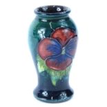 A Moorcroft miniature pottery vase, decorated with two pansies on a turquoise ground, impressed mark