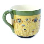 A Macintyre Moorcroft pottery cup, decorated with a design of poppies on a brown ground, with a