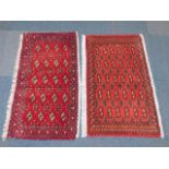 A near pair of Takoma small rugs, red ground, each 105cm x 50cm.
