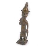 A Benin bronze figure of a tribesman, modelled standing in a lion cloth, with plaited hair,
