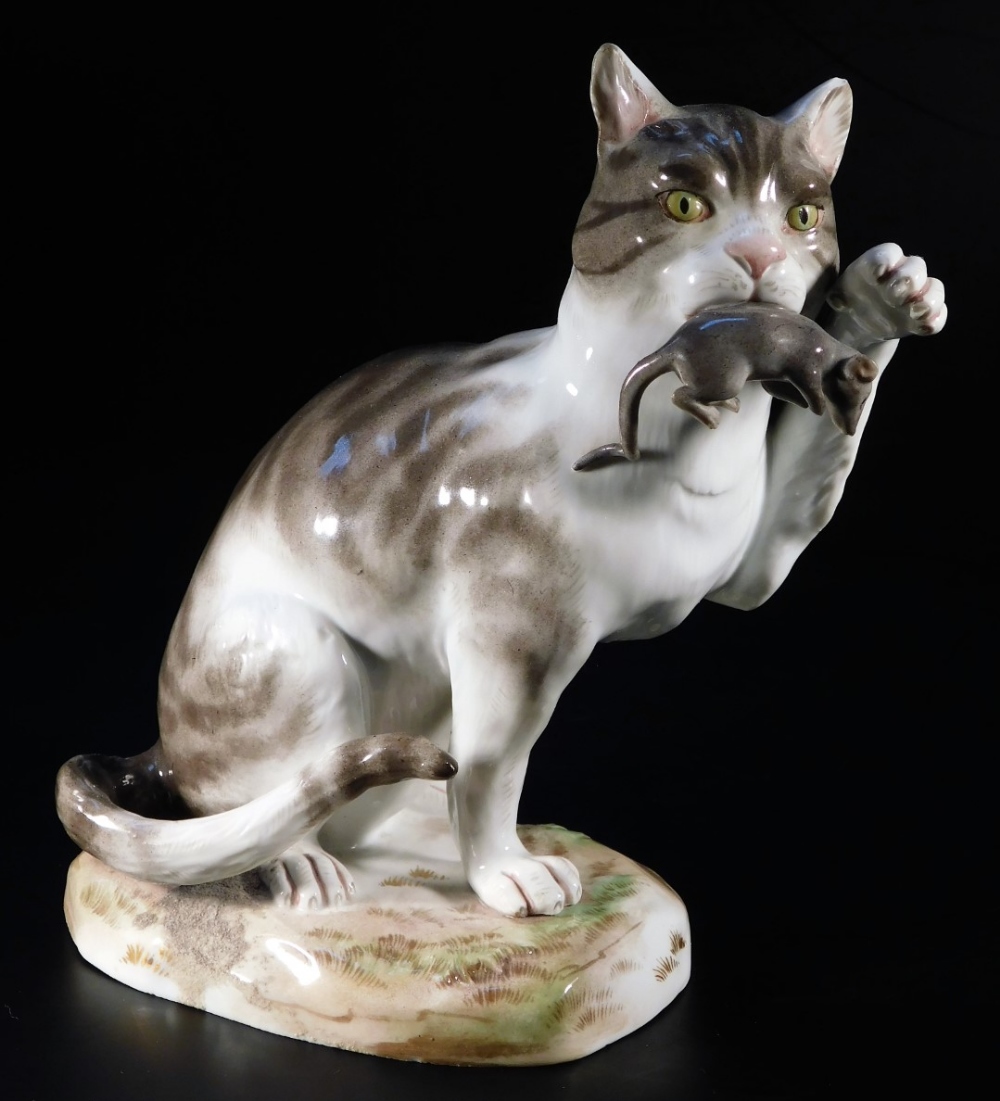 A 19thC Meissen porcelain figure of a cat, in standing pose with paw raised, with rat to mouth, in