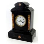 A French black slate and marble portico type mantel clock, the shaped top above two cylindrical