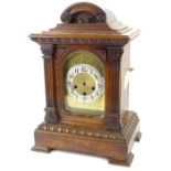 An early 20thC German walnut mantel clock, with arched engraved dial, silvered chaptering and carved