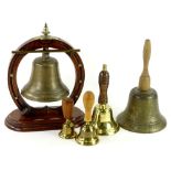 A collection of bells, to include a dinner gong on carved oak horse shoe shaped stand with silver