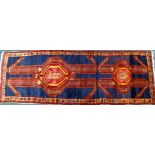 An Azari runner, with a long pole type medallion in red, orange, pink etc., on a navy ground with