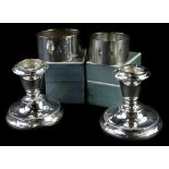 A collection of small silver, to include a pair of dwarf candlesticks (AF) and two silver napkin