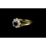 A 9ct gold cluster dress ring, with central dark blue stone, surrounded by imitation diamonds,