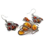 An amber set brooch and earring set, the brooch in silver frame with similar design silver drop