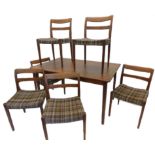 A Swedish retro style teak extending dining table, on turned tapering legs, and a