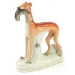A Victorian Staffordshire greyhound, modelled with a hare in its mouth, 28cm H.