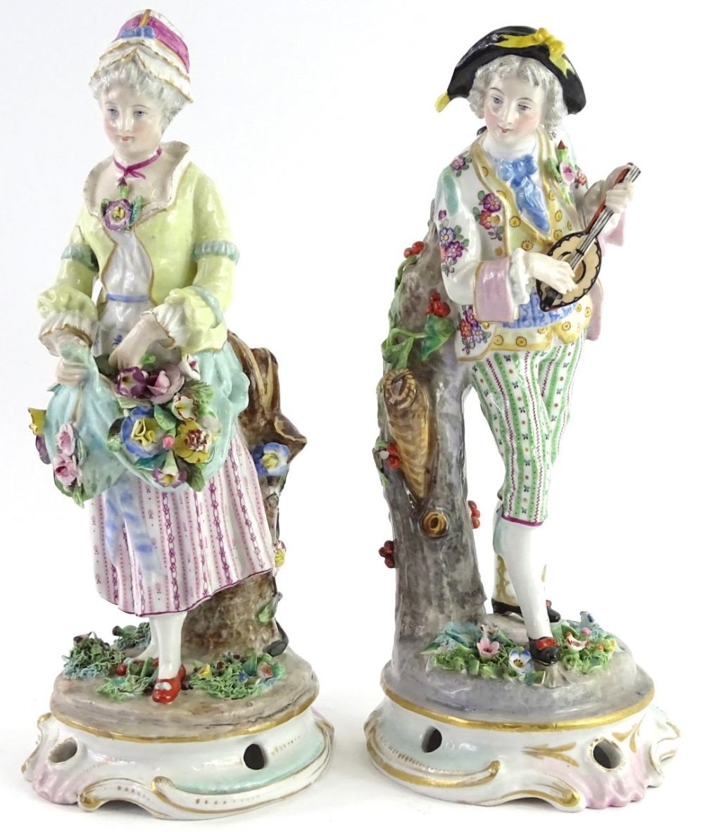 A pair of German porcelain figurines, each modelled in the form of musician and a lady carrying