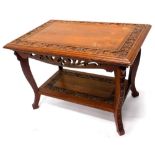 An early 20thC teak two tier table in Art Nouveau style, the rectangular top with floral carved