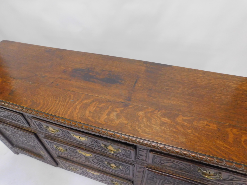 A 19thC oak dresser base, carved overall with scrolls etc., with an arrangement of five drawers - Image 2 of 2