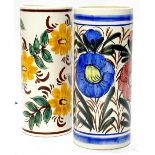 A pair of Continental pottery umbrella stands, each decorated in bright colours with flowers,
