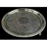 A George III circular silver waiter, with a gadrooned border, engraved overall with scrolls,