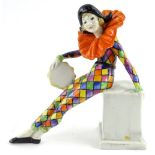 A Wade Art Deco porcelain figure, modelled in the form of a female harlequin carrying a tambourine
