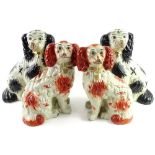 Two pairs of Staffordshire type porcelain figures, each decorated in brown and black, and with
