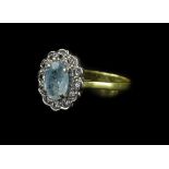 An 18ct gold aquamarine and diamond cluster ring, with central oval cut aquamarine in claw