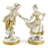 A pair of German porcelain figures, each modelled in the form of a gentleman and lady with flower