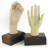 A pair of late 20thC mannequin hands, each mounted on a wooden block to convert to a ring stand, the