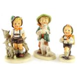 Three Goebel Hummel figures, to include a boy with goat, boy with lambs etc.