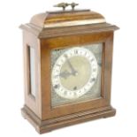 A German mantel clock in George III style, in oak case, the square dial with gilt metal spandrels
