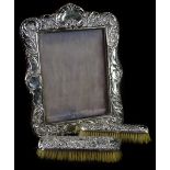 An early 20thC silver mounted photograph frame, decorated with scrolls, (AF) and two silver