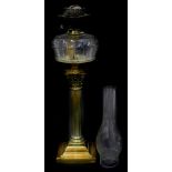 A late 19th/early 20thC corinthian column brass oil lamp, with a clear reservoir, on square base,