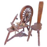 A 20thC carved teak spinning wheel, decorated overall with flowers etc., and a matching spinning
