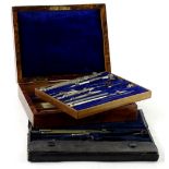 A set of late 19th/early 20thC drawing instruments, in figured walnut case and another part set.