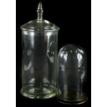 A large glass chemist or lab type storage jar, with turned finial, 55cm H and a glass dome on a