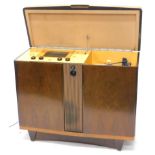 A KB radiogram, in a figured walnut case, the hinged lid enclosing a radio with Bakelite fittings