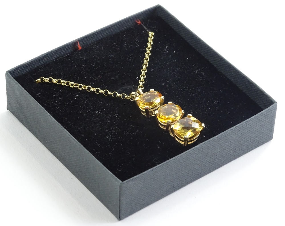 A three stone citrine pendant, the citrines of three stone drop, in a 9ct gold claw setting, the two