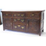 A 19thC oak dresser base, carved overall with scrolls etc., with an arrangement of five drawers
