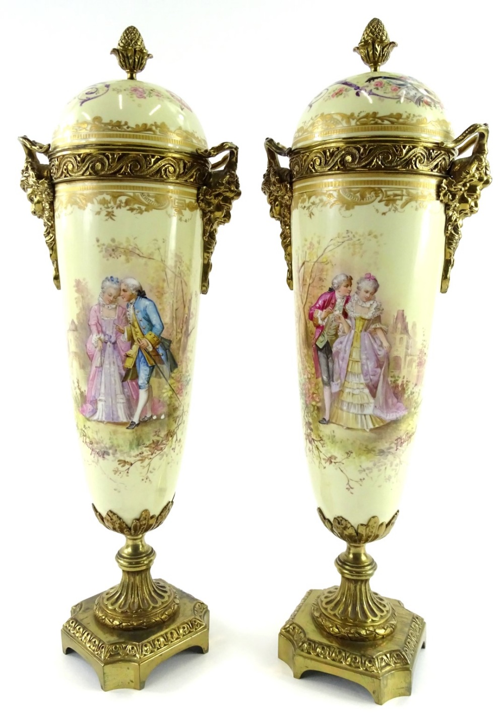 A pair of Sevres style porcelain urns and covers, each with gilt metal mounts and decorated with