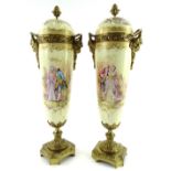 A pair of Sevres style porcelain urns and covers, each with gilt metal mounts and decorated with