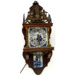 A Dutch wall clock, the top inset with a gilt metal figure of Atlas, the Delft type dial decorated