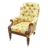 A Victorian mahogany armchair, upholstered in brightly coloured floral fabric, the leaf carved arm