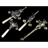 A collection of four silver coloured metal babies rattles, with teethers, to include Mr Punch, two