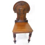 A Victorian oak hall chair, with shield shaped back and a solid seat on turned tapering legs.