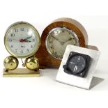 A small collection of clocks, to include a Nero Lemonia car clock, a small alarm clock and an oak