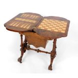 A Victorian walnut games and sewing table, with burr yew crossbanding to the hinged top opening to